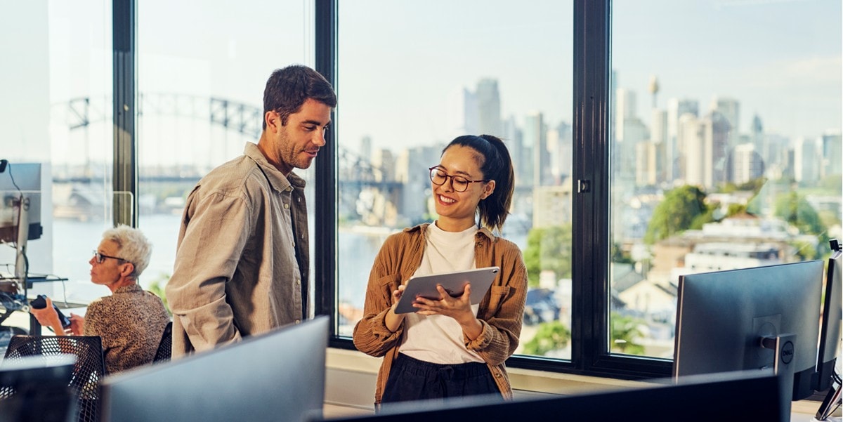 two people in the office reviewing a tablet