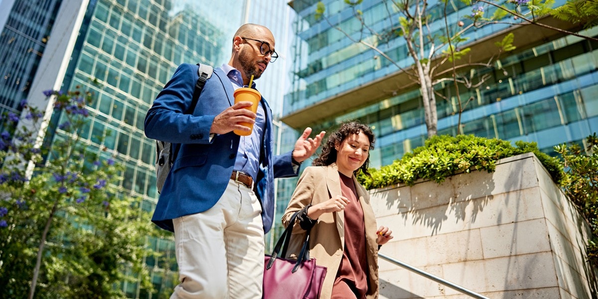 two professionals walking down steps, outside of office building