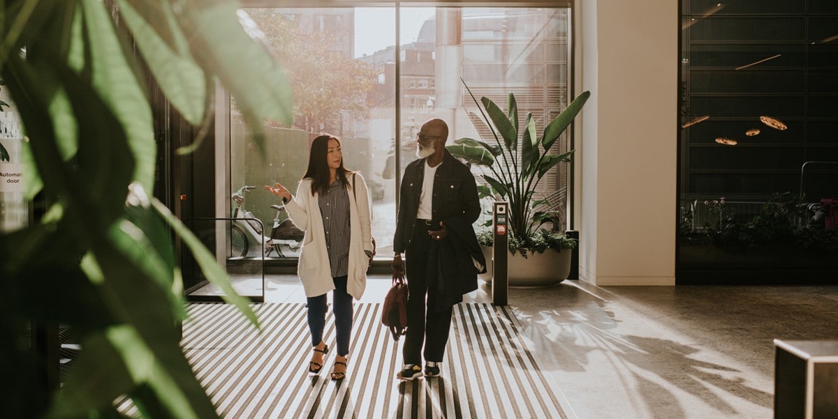 two people walking in a building lobby