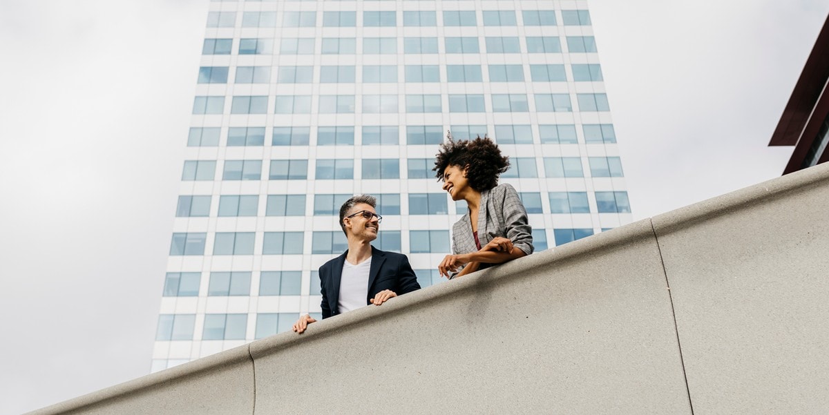 two professional standing on balcony outside an office building