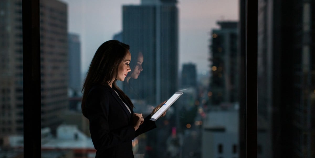 woman standing in office, looking at tablet