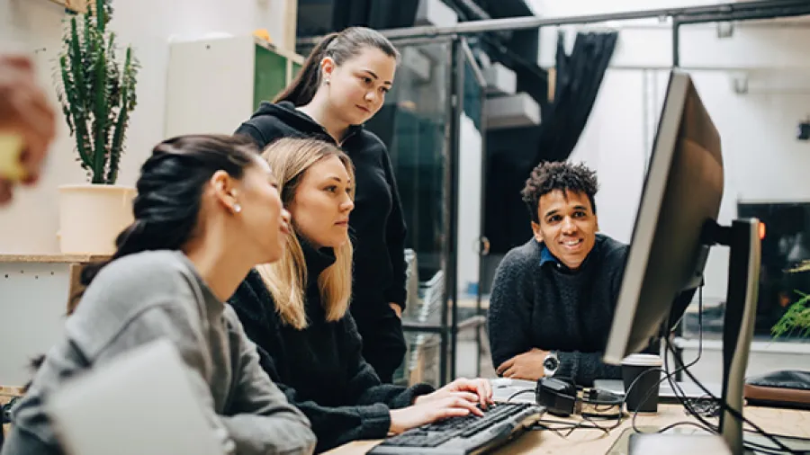 group on four people discussing work on a laptop