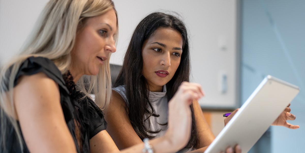 two businesswomen working together on a tablet