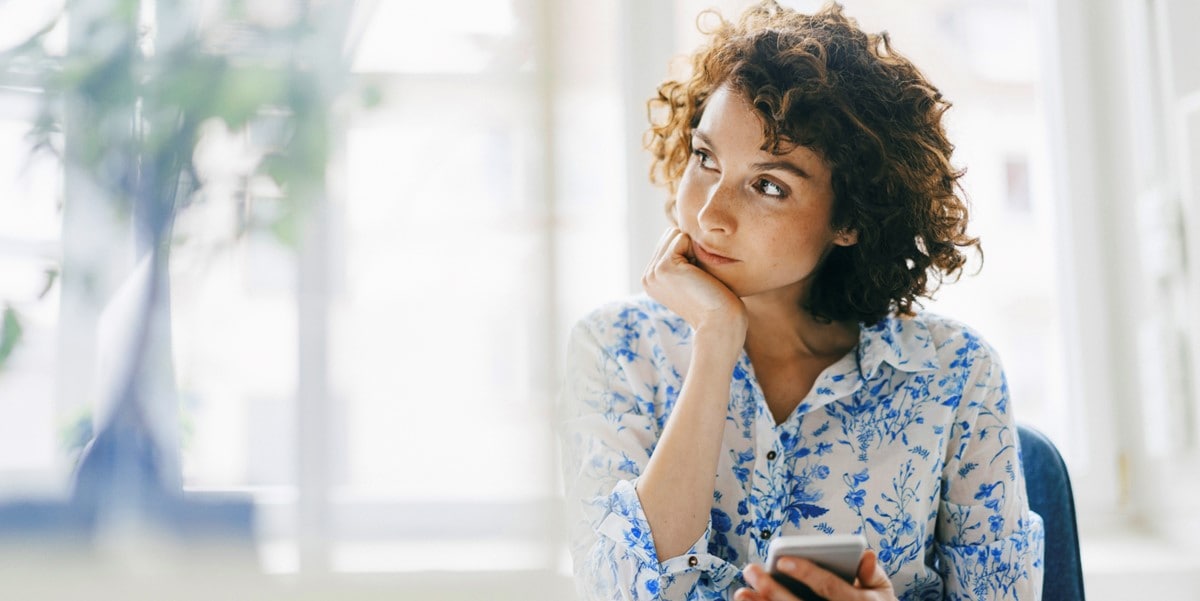 woman in office with phone in hand