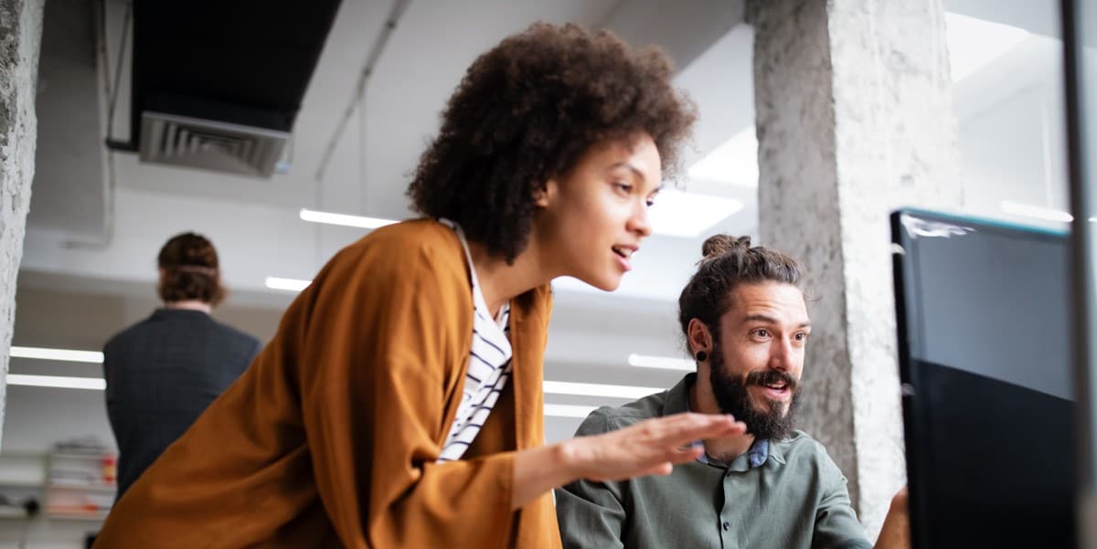 two people in the office looking at computer