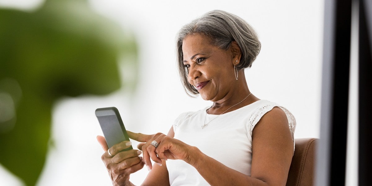 woman smiling looking at her phone