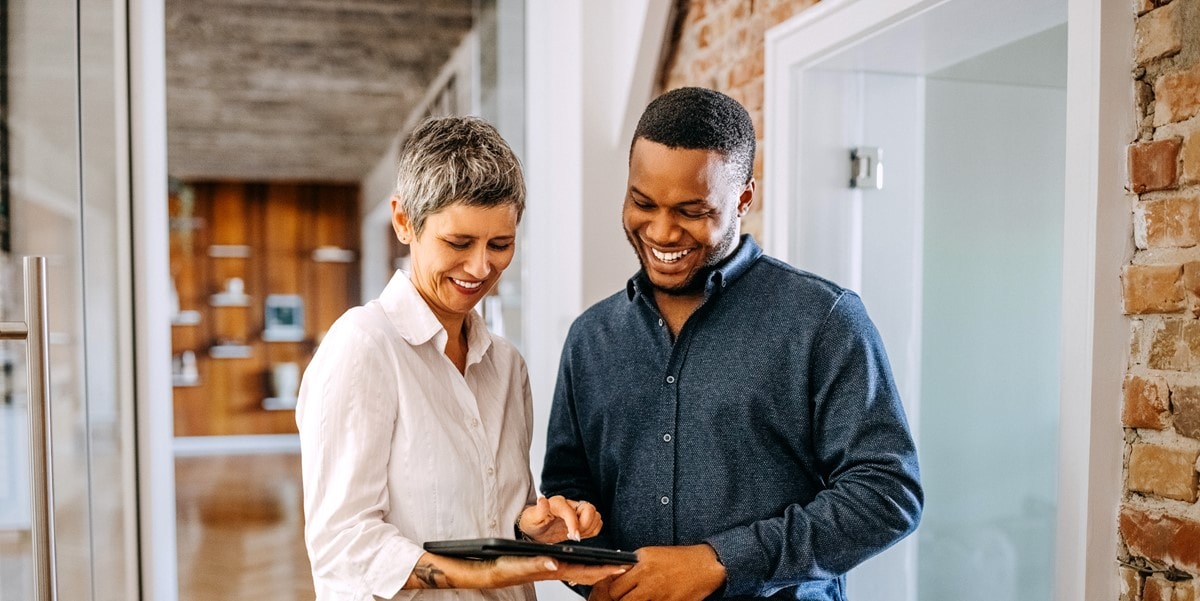 two professionals in office looking at a document