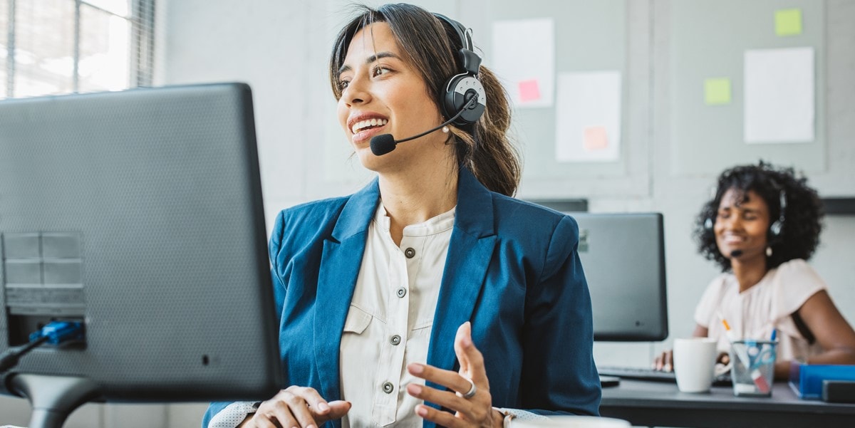 professional women at desk on calls, with headsets