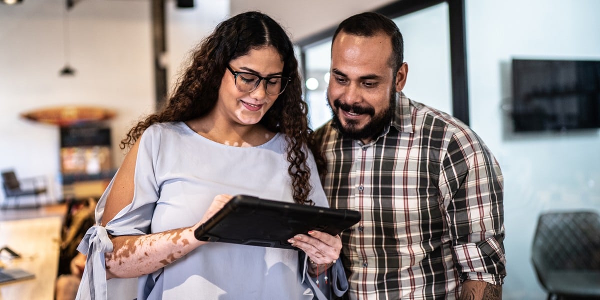 two people in the office reviewing document