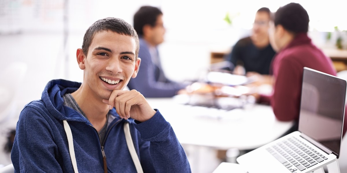 man sitting at desk with laptop