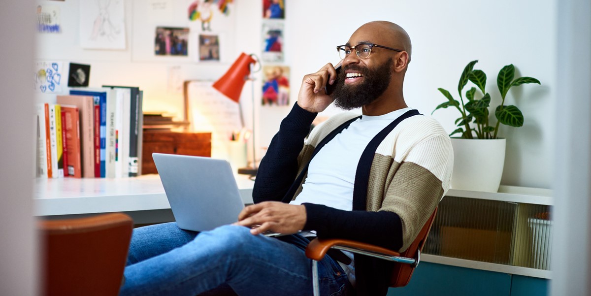 man sitting in office on the phone