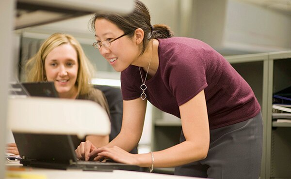 woman in glasses looking at computer