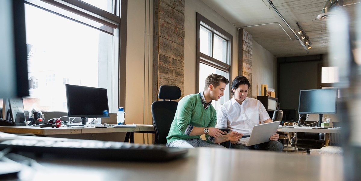 two people working on a laptop