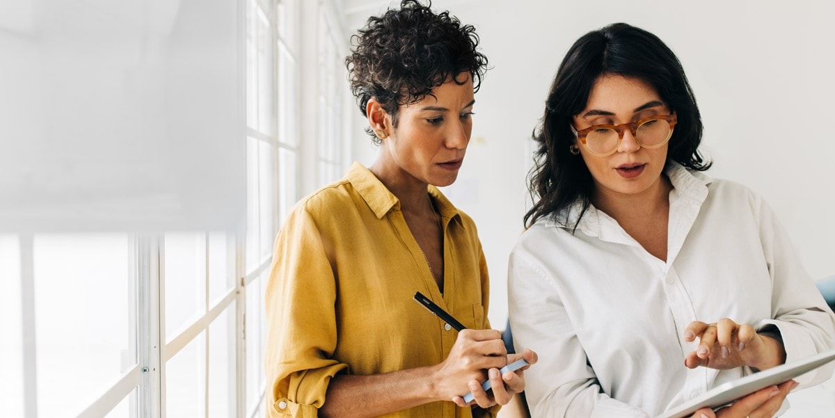 two women in office looking at document