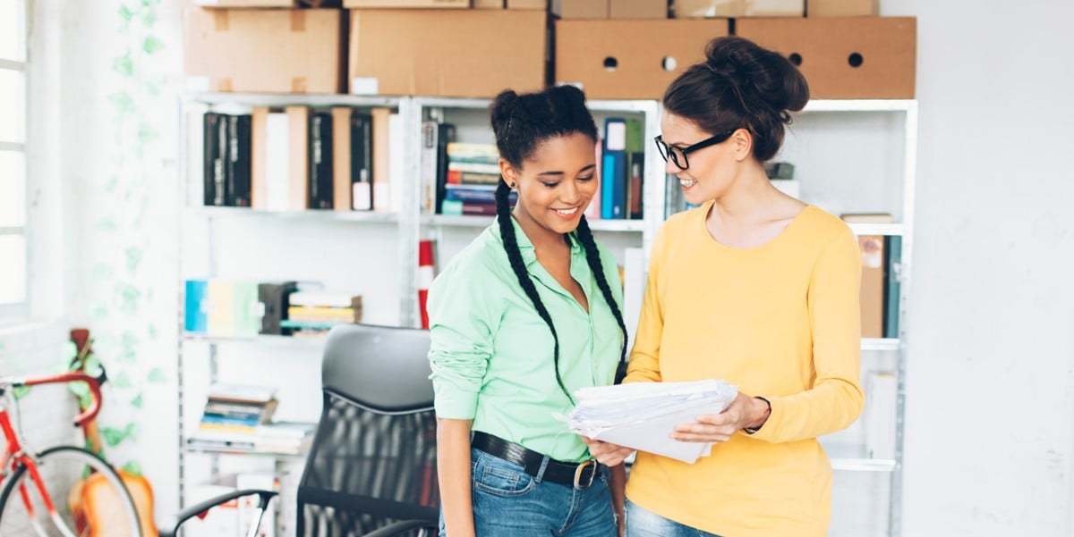 two women looking at document in office