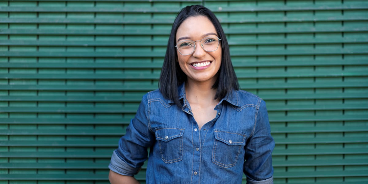 woman smiling in front of green wall